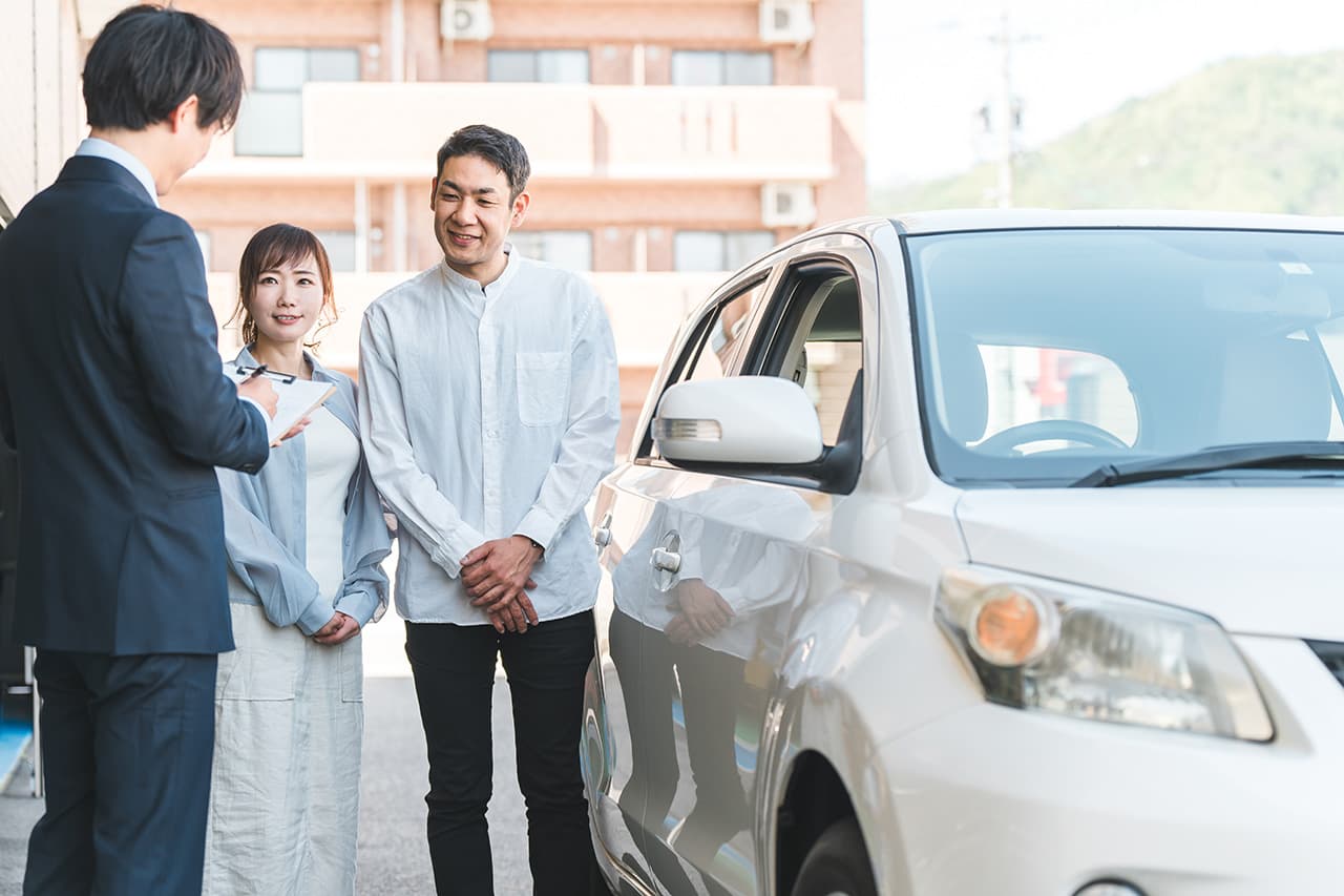 営業マンがご夫婦に車両の説明をしている様子